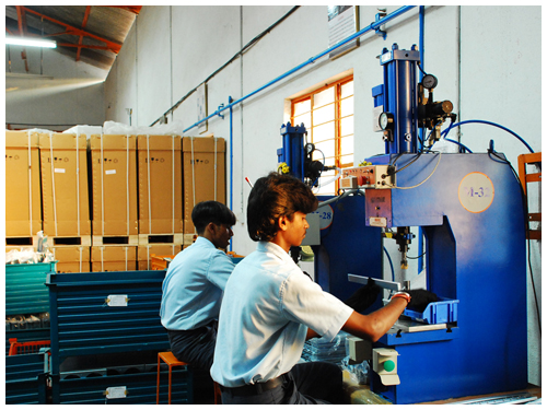 Operator working at a hydraulic press station on the shop floor