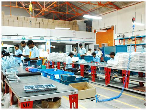 Final assembly line with parts staged in bins along the benches