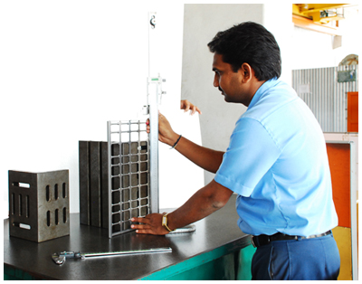Sigma Metaliks engineer checking a fabricated sheet metal assembly against a height gauge on the inspection bench